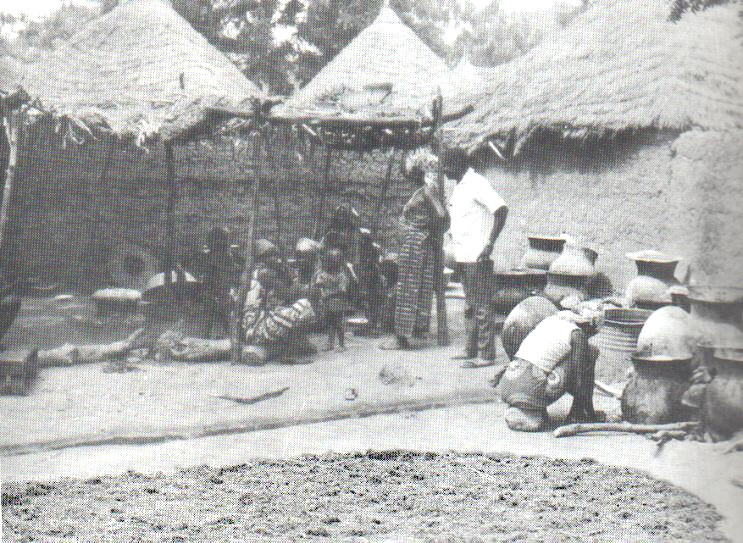 Séchage du sorgho germé étalé au soleil (premier plan), matériel de brassage à droite.
